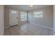 Bright living room with tile flooring, a white front door, and windows with natural light at 73 Channing Ave, Orlando, FL 32811