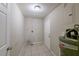 Utility room featuring tile flooring, white walls, water heater and a door at 73 Channing Ave, Orlando, FL 32811