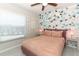 Cozy bedroom features geometric wallpaper, a bed with bedding and side tables with lamps at 7834 Turkey Oak Ln, Kissimmee, FL 34747