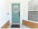 Charming teal front door with decorative window, welcome mat, and a modern smart lock at 7834 Turkey Oak Ln, Kissimmee, FL 34747