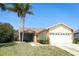 Charming single-story home with a two-car garage, tropical landscaping, and a well-manicured lawn at 7834 Turkey Oak Ln, Kissimmee, FL 34747