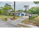 Exterior view of the single-story home with a blue garage door, a well-manicured lawn, and mature trees at 801 Fox Valley Dr, Longwood, FL 32779
