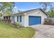 View of the home exterior with a blue garage door, blue shutters, and green lawn at 801 Fox Valley Dr, Longwood, FL 32779