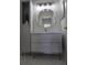 Bathroom featuring a vanity with storage, a round mirror, and hexagon tile floors at 8775 Sartori St # 302, Orlando, FL 32829