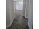 Hallway with gray wood-look flooring leading to a living room with chandelier at 8775 Sartori St # 302, Orlando, FL 32829