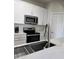 Modern kitchen featuring stainless steel appliances, white cabinets, and light countertops at 8775 Sartori St # 302, Orlando, FL 32829