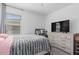 Well-lit bedroom featuring a large bed with a grey blanket and a vanity area at 944 Flyer St, Orange City, FL 32763