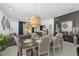 Open-concept dining area with modern light fixture, seamlessly flowing into the living room at 944 Flyer St, Orange City, FL 32763