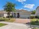 Charming single-story home featuring a well-maintained lawn and inviting brick driveway, with stone column accents at 944 Flyer St, Orange City, FL 32763