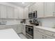 This modern kitchen features stainless steel appliances and sleek, white countertops and cabinets at 944 Flyer St, Orange City, FL 32763