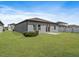 A home's backyard featuring a patio, green grass, and a partial fence line at 1030 Alabaster Way, Deltona, FL 32725