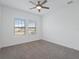 Bright bedroom with carpet, ceiling fan, and windows offering natural light and neighborhood views at 1030 Alabaster Way, Deltona, FL 32725