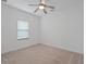 A cozy bedroom with plush carpet, ceiling fan, and a window, perfect for a restful retreat at 1030 Alabaster Way, Deltona, FL 32725