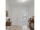 Inviting entryway featuring neutral tile flooring, white walls, and decor-enhancing wooden furniture at 1030 Alabaster Way, Deltona, FL 32725