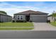 Charming one-story home with a well-manicured lawn, gray exterior, and attached two-car garage at 1030 Alabaster Way, Deltona, FL 32725