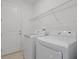 Clean laundry room features a washer, dryer, and overhead shelving for storage at 1030 Alabaster Way, Deltona, FL 32725