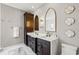 Stylish bathroom featuring dual sinks with dark wood cabinets and decorative wall accents at 13638 Sunset Lakes Cir, Winter Garden, FL 34787