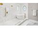 Luxurious bathroom with freestanding tub, white marble tiles, and elegant gold fixtures at 13638 Sunset Lakes Cir, Winter Garden, FL 34787