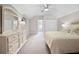 Spacious bedroom with a ceiling fan, large mirror, and cream colored walls and carpet at 13638 Sunset Lakes Cir, Winter Garden, FL 34787