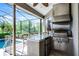 Outdoor kitchen and bar area next to a swimming pool in the backyard at 13638 Sunset Lakes Cir, Winter Garden, FL 34787