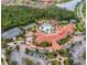Aerial view of a community clubhouse with a pool, tennis courts, and ample parking surrounded by lush greenery at 1390 Harbor Ridge Dr, Kissimmee, FL 34759