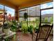 Enclosed sunroom featuring brick floors, large windows, and a variety of thriving potted plants at 1390 Harbor Ridge Dr, Kissimmee, FL 34759