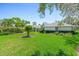Expansive backyard with lush lawn and mature trees provides a serene outdoor space at 203 Prestwick Dr, New Smyrna Beach, FL 32168