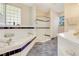 Bright primary bathroom with separate tub, glass shower, and ample vanity storage at 203 Prestwick Dr, New Smyrna Beach, FL 32168