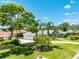 Landscaped front yard featuring vibrant green grass, mature trees, and a charming home with a three-car garage at 203 Prestwick Dr, New Smyrna Beach, FL 32168