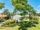 Beautifully landscaped front yard with mature trees, green lawn, and a well-maintained home with three-car garage at 203 Prestwick Dr, New Smyrna Beach, FL 32168
