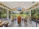 Bright sunroom with slate floors, walls of windows, and scenic views of the lush backyard at 203 Prestwick Dr, New Smyrna Beach, FL 32168