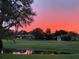 Scenic sunset view over a tranquil pond and lush green golf course creating a serene backdrop for the homes at 203 Prestwick Dr, New Smyrna Beach, FL 32168