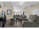 Comfortable living area with hardwood-style flooring, neutral walls, gray sofa, and access to the kitchen at 335 Snook Way, Poinciana, FL 34759