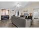 Spacious living room with a gray sectional sofa, modern ceiling fan, bar, and access to the bathroom at 335 Snook Way, Poinciana, FL 34759