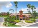 Beautiful community clubhouse featuring landscaped grounds with mature palm trees and fountain at 4103 Tropical Isle Blvd # 132, Kissimmee, FL 34741
