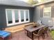 Private brick patio with outdoor seating, charming decor, and new wooden deck off of French doors at 750 Hempstead Ave, Orlando, FL 32803