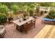 Beautiful outdoor brick patio features a dining table, bench, lounge chair, and plenty of lush greenery at 750 Hempstead Ave, Orlando, FL 32803