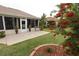 Well-maintained backyard featuring a screened lanai, lush landscaping, and a relaxing outdoor space at 1669 Plum Branch Ter, The Villages, FL 32162