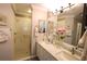 Bathroom with double vanity, granite counters, white cabinets, and walk-in shower at 1669 Plum Branch Ter, The Villages, FL 32162