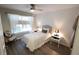 Cozy bedroom features hardwood floors, natural light, neutral decor, and a ceiling fan at 1669 Plum Branch Ter, The Villages, FL 32162