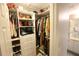 Walk-in closet with custom shelving and storage options, and access to en-suite bathroom at 1669 Plum Branch Ter, The Villages, FL 32162