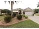 Charming single-story home featuring a lush landscaped yard, complemented by a cozy front porch and a two-car garage at 1669 Plum Branch Ter, The Villages, FL 32162