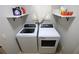 Laundry area with modern washer and dryer, neutral walls, floating shelves and natural light at 1669 Plum Branch Ter, The Villages, FL 32162
