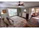 Primary bedroom features wood flooring, ceiling fan, large window, and adjoining sitting room at 1669 Plum Branch Ter, The Villages, FL 32162
