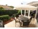 Inviting outdoor patio with a dining set, umbrella, and well-manicured landscaping, ideal for entertaining at 1669 Plum Branch Ter, The Villages, FL 32162