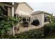 Outdoor patio featuring a dining table, grill, and lush greenery, perfect for outdoor gatherings at 1669 Plum Branch Ter, The Villages, FL 32162