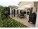 Outdoor patio with a dining set and lush landscaping, providing a serene and relaxing atmosphere at 1669 Plum Branch Ter, The Villages, FL 32162