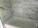 Modern bathroom features new bathtub with updated marble tile surround at 2451 W 18Th St, Sanford, FL 32771