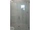 Modern bathroom with glass-enclosed shower featuring elegant marble-look tiles and hexagon-shaped flooring at 2451 W 18Th St, Sanford, FL 32771