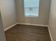Cozy bedroom with wood-look floors, a window, neutral gray paint and white trim at 2451 W 18Th St, Sanford, FL 32771